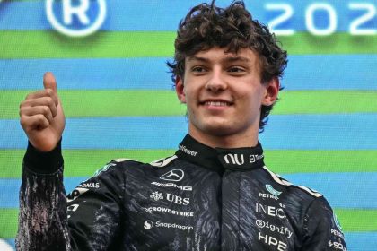 Antonelli celebrates victory at the Japanese Grand Prix, giving a thumbs-up to the crowd after a dramatic safety car twist.