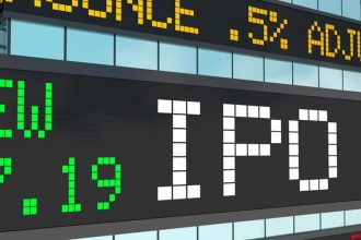 Close-up of a stock exchange-style electronic display with the word “IPO” in large white block letters, surrounded by green and yellow ticker text and numbers on black screens.