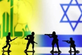 Silhouettes of armed figures in front of split Hezbollah and Israeli flags.