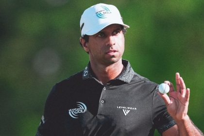Golfer Aaron Rai holds up a golf ball while standing on the course after his U.S. PGA Championship win at Aronimink Golf Club.