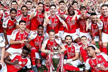 Arsenal players celebrate together with the Premier League trophy.