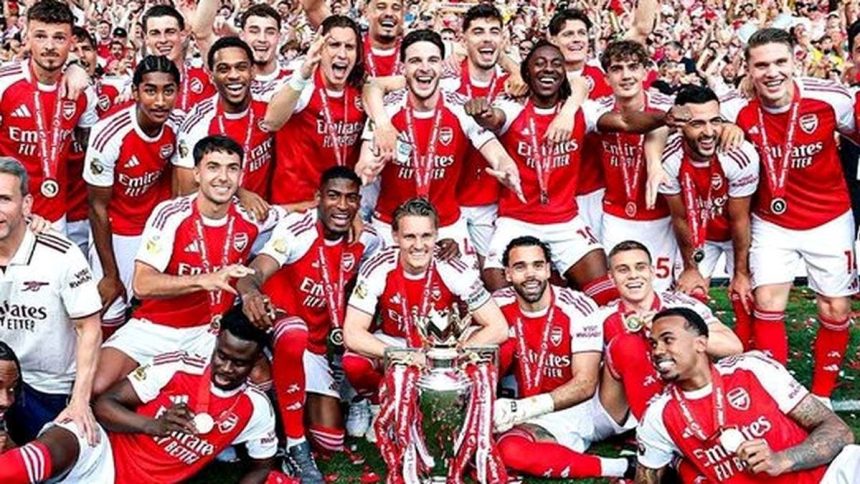 Arsenal players celebrate together with the Premier League trophy.