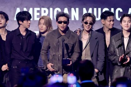 BTS members stand onstage with an award at the 2026 American Music Awards.