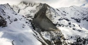 Aerial view of a snow-covered Alpine glacier and rocky mountain slope near Blatten