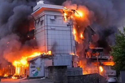 A building in Kyiv burns with large flames and heavy black smoke after missile attack debris reportedly caught fire on school premises.