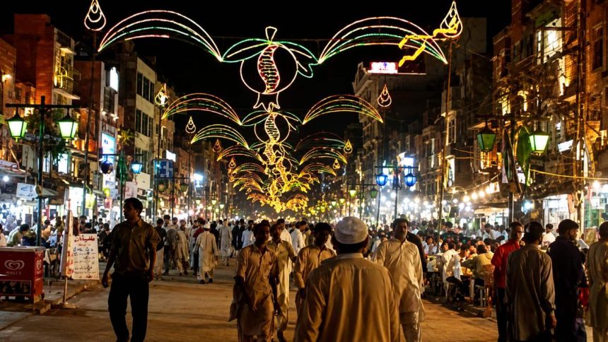 Lahore market glows with festive lights at night.