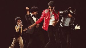 Promotional image showing different age portrayals of Michael Jackson performing and dancing on a dark stage.