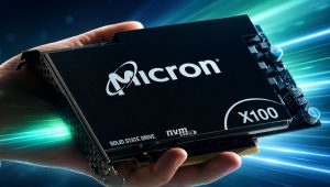 Micron X100 SSD held in a hand against blue and green light trails in a high-tech promotional image.
