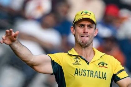 Australia captain Mitchell Marsh in a yellow Australia cricket kit throwing a ball on the field.