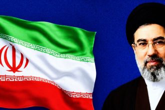 Iran’s Supreme Leader Mojtaba Khamenei appears beside a waving Iranian flag against a blue background.