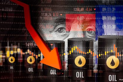 Oil barrels stand in front of falling market charts and a large red arrow showing oil prices dropping.