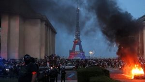 A burning car, fireworks and police are seen as PSG supporters celebrate in Paris after the Champions League final.