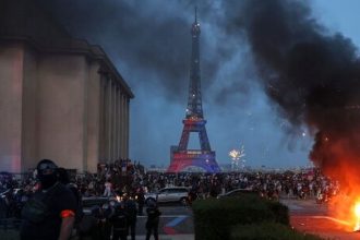 A burning car, fireworks and police are seen as PSG supporters celebrate in Paris after the Champions League final.
