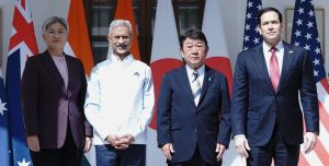 Four Quad foreign ministers stand in front of national flags during a formal QUAD FMM photo session.