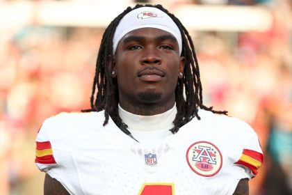 Kansas City Chiefs wide receiver Rashee Rice wears a white Chiefs uniform and headband while standing on the field.