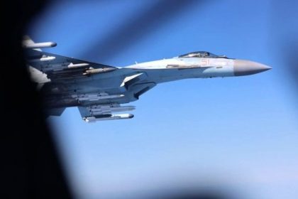 A Russian fighter jet flies through clear blue sky during an aerial interception involving RAF aircraft.