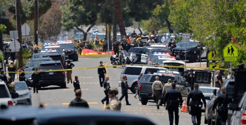 Police vehicles and officers block a street near the Islamic Center of San Diego after a reported mosque shooting in California.
