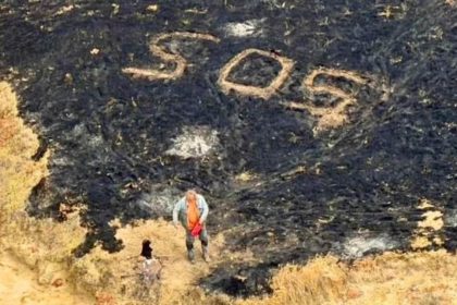 An SOS sign is marked on charred land after a wildfire on Santa Rosa Island in California.