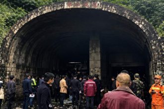 A group of people and emergency workers stand outside a coal mine tunnel entrance in Shanxi, China, after a reported blast.