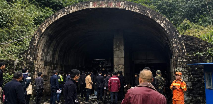 A group of people and emergency workers stand outside a coal mine tunnel entrance in Shanxi, China, after a reported blast.