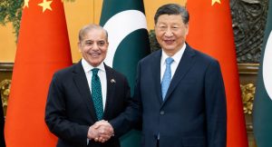 Xi Jinping and Shehbaz Sharif shake hands in front of Chinese and Pakistani flags during a meeting in Beijing.