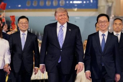 President Donald Trump walks with officials after arriving in Beijing for the first state visit to China by a U.S. leader in nine years.
