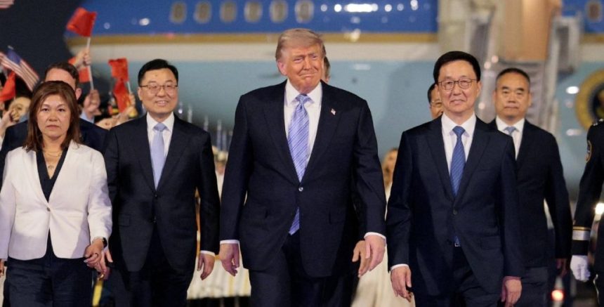 President Donald Trump walks with officials after arriving in Beijing for the first state visit to China by a U.S. leader in nine years.