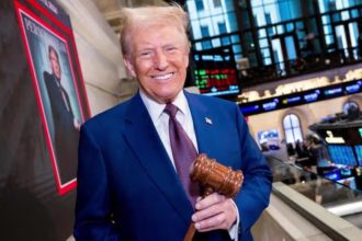 President-elect Donald Trump smiles while holding a gavel at the New York Stock Exchange during a visit to ring the Opening Bell.