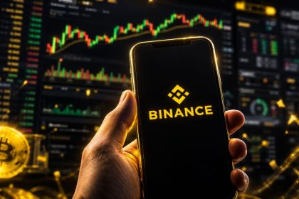 Binance logo on a smartphone with cryptocurrency trading charts and Bitcoin graphics in the background.