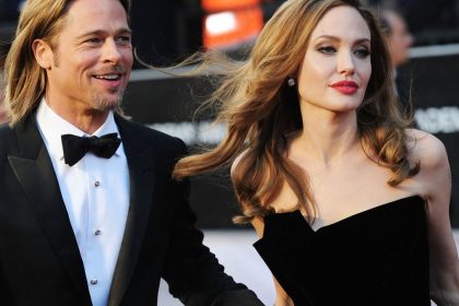 Brad Pitt and Angelina Jolie walking together at a red-carpet entertainment event.