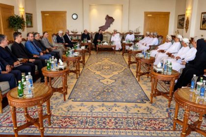 Iranian and Omani officials seated in a formal meeting room in Muscat for the first Iran-Oman Hormuz Committee meeting.