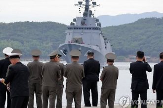 Kim Jong-un and officials watching the North Korean naval destroyer Kang Kon during sea trials.