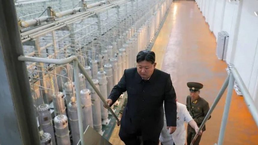 Kim Jong Un walks inside a uranium enrichment facility with industrial equipment and officials nearby on Sptember 13, 2024.