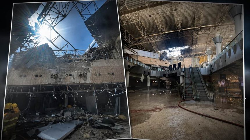 A damaged airport interior shows collapsed roof sections, debris, water on the floor, and an escalator after a reported Iranian missile attack.