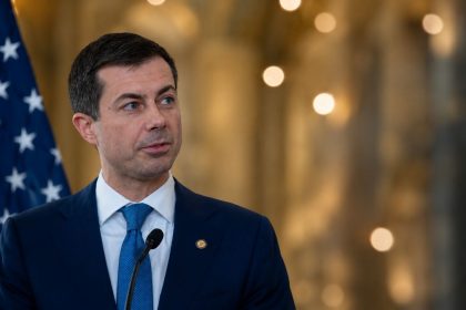 Transportation Secretary Pete Buttigieg speaking at a press conference at Ronald Reagan National Airport.