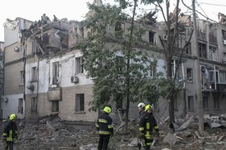 Rescue workers outside a damaged residential building in Dnipro after a deadly attack.