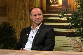 Israeli Christian leader Shadi Khalloul sits at a table during an interview-style discussion.