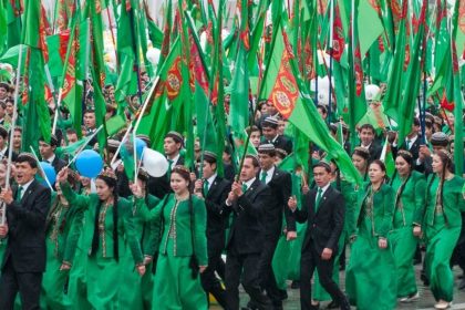 Turkmen activists holding national flags during a public gathering.