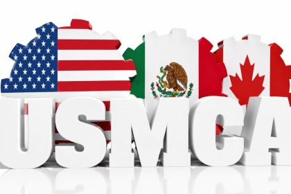 USMCA letters displayed with the United States, Mexico and Canada flags in a trade agreement graphic.