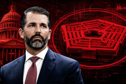 Donald Trump Jr. appears in front of a red-and-black political graphic showing the U.S. Capitol and Pentagon