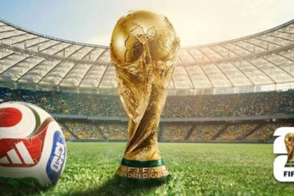 FIFA World Cup trophy and football on a stadium pitch.