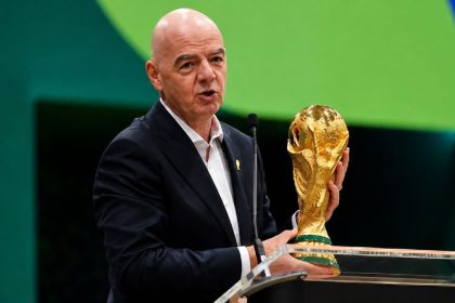 FIFA President Gianni Infantino holds the FIFA World Cup Trophy while addressing an audience at an official event. Image Credit: AP.