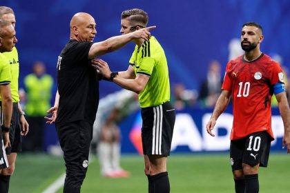Egypt coach Hossam Hassan argues with referee Francois Letexier during Argentina vs Egypt World Cup match.