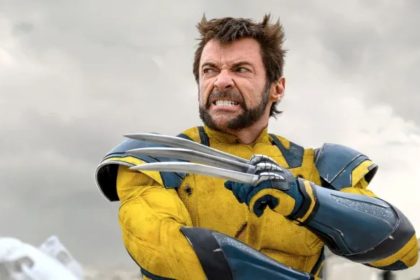 Hugh Jackman as Wolverine wearing a yellow-and-blue suit with metal claws extended.