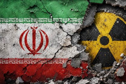 Iranian flag on cracked wall with nuclear radiation symbol