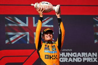 McLaren driver Lando Norris lifts the winner's trophy after winning the 2025 Hungarian Formula One Grand Prix at the Hungaroring in Mogyoród, Hungary.