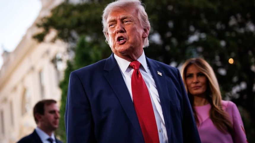 Donald Trump speaking with Melania Trump in the background.