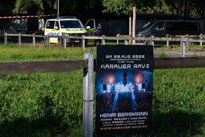 Police secure the area behind a rave poster in Aarau after a shooting.
