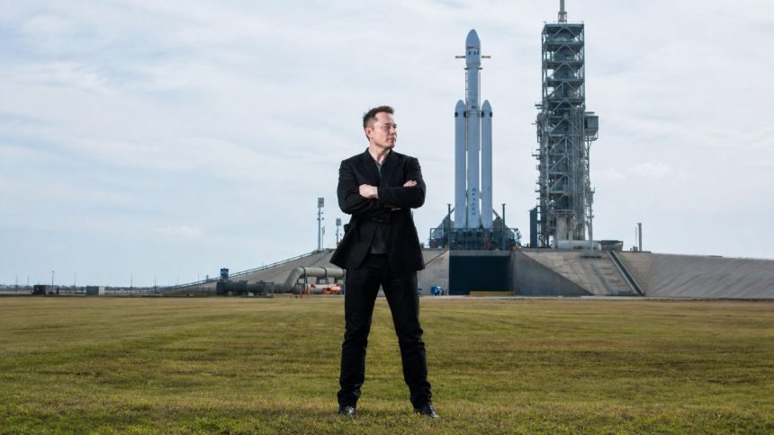 Elon Musk standing in front of a SpaceX rocket.