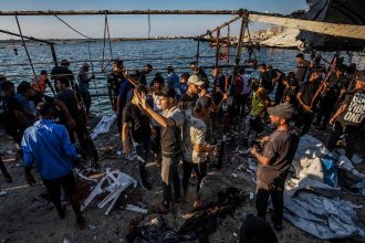 Palestinians inspect a cafe destroyed in an Israeli airstrike at Gaza port